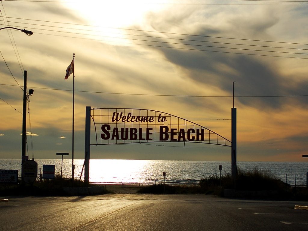 Photo of the Welcome to Sauble Beach sign silhouetted against the sky