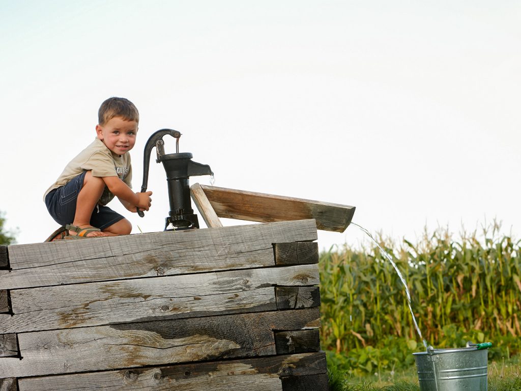 boy at a water pump