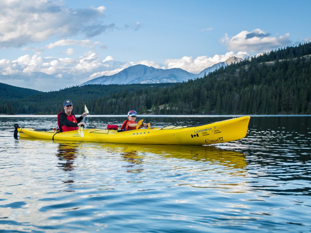 kayaking on lake by mountains