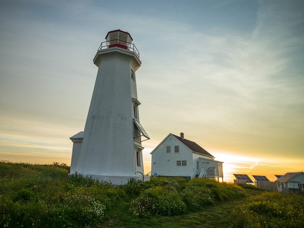 a lighthouse and keeper's house at sunset