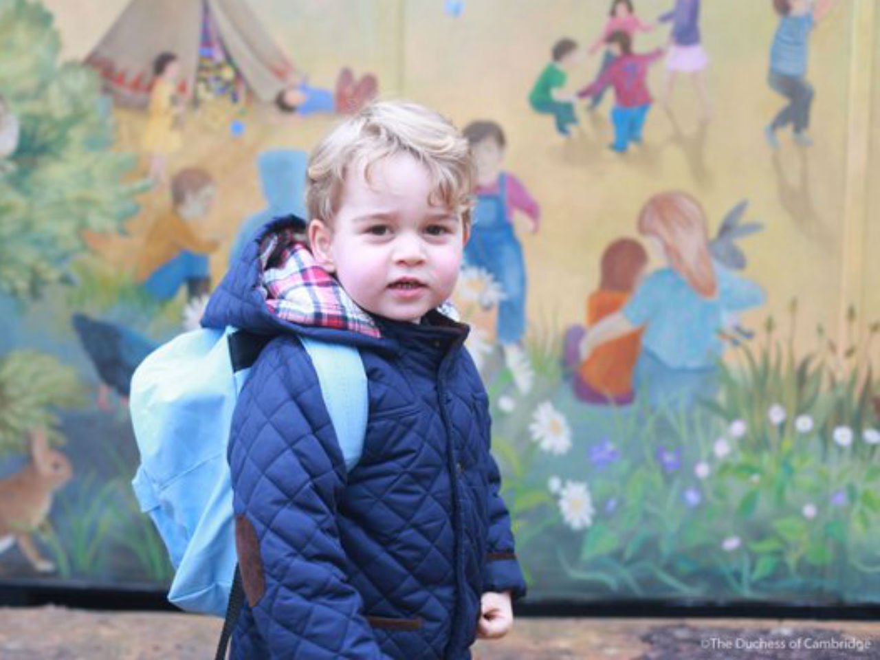 Prince George smiling while wearing a blue backpack