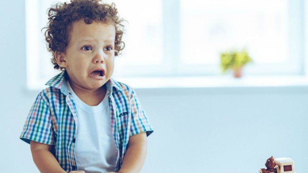 Young boy getting visibly upset during his terrible twos phase