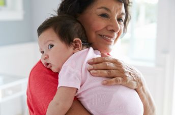 Grandma smiling while holding baby girl