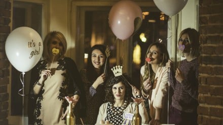 a group of women gather together for a nighttime baby shower