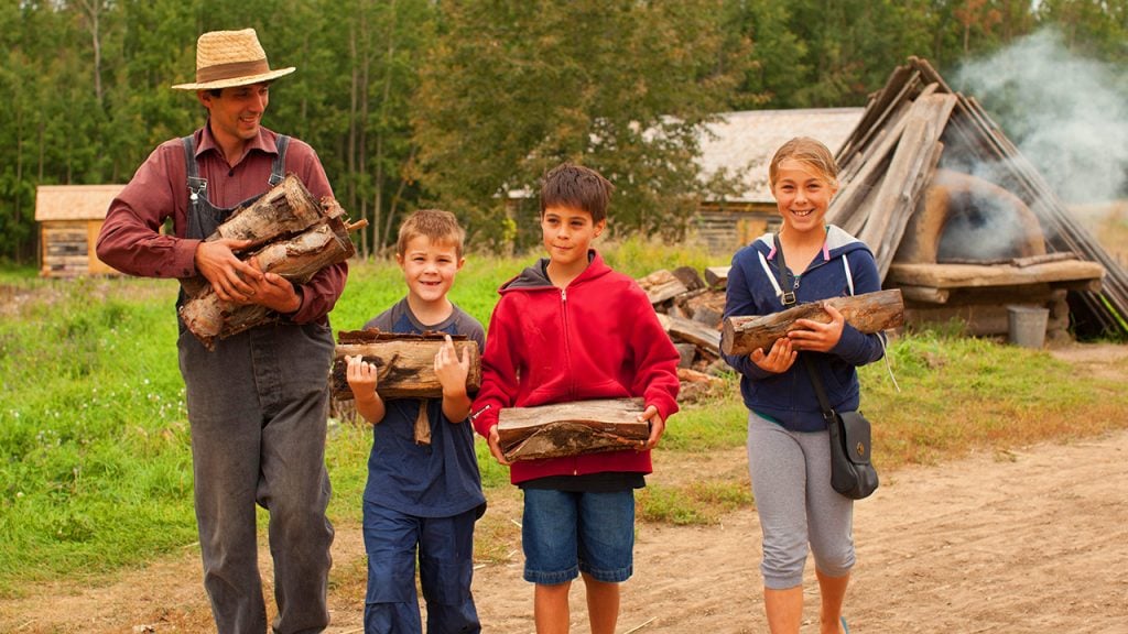 Kids help carry some wood at the Ukrainian Heritage Cultural Village near Edmonton, AB