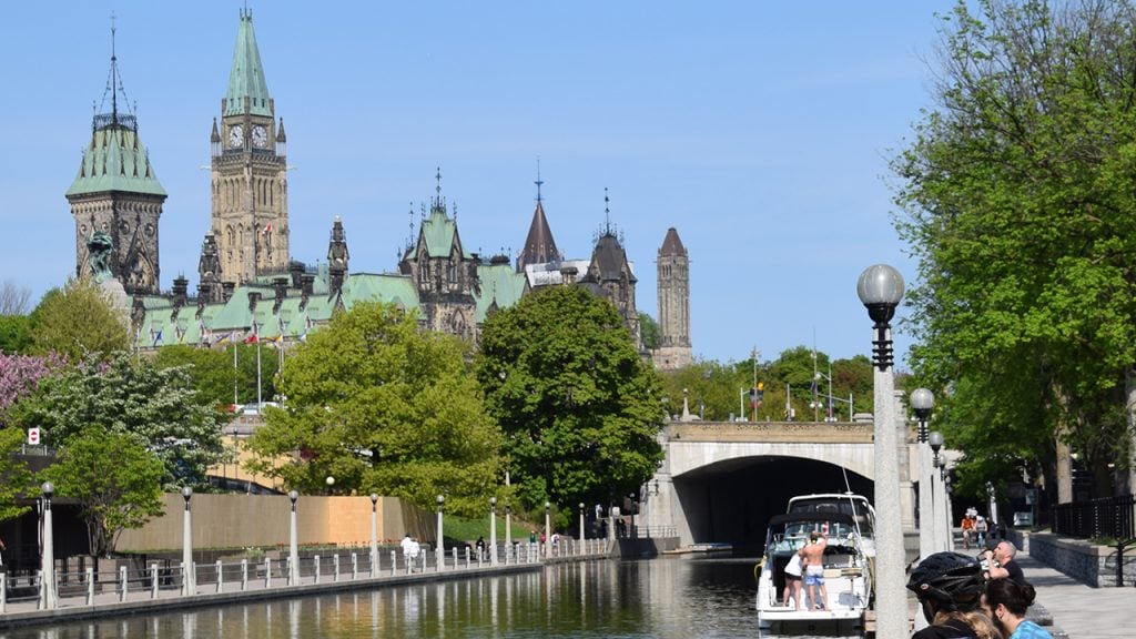View of Parliament Hill from the bike path along the Rideau Canal in Ottawa, ON
