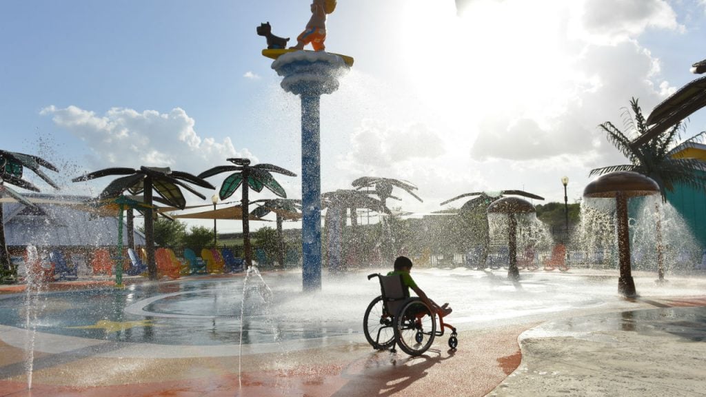 a child in a wheelchair plays at the waterpark