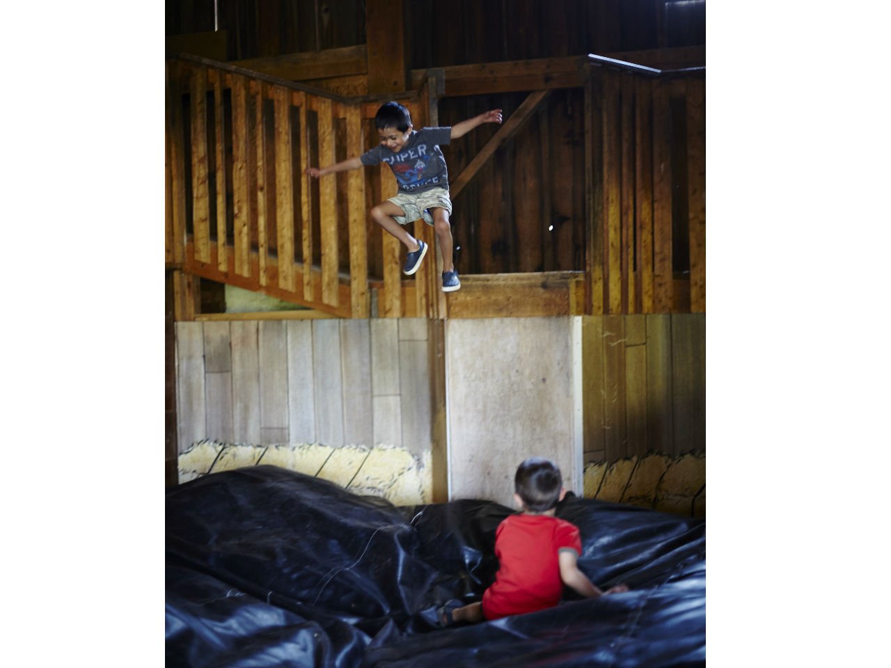 two brothers playing in a barn
