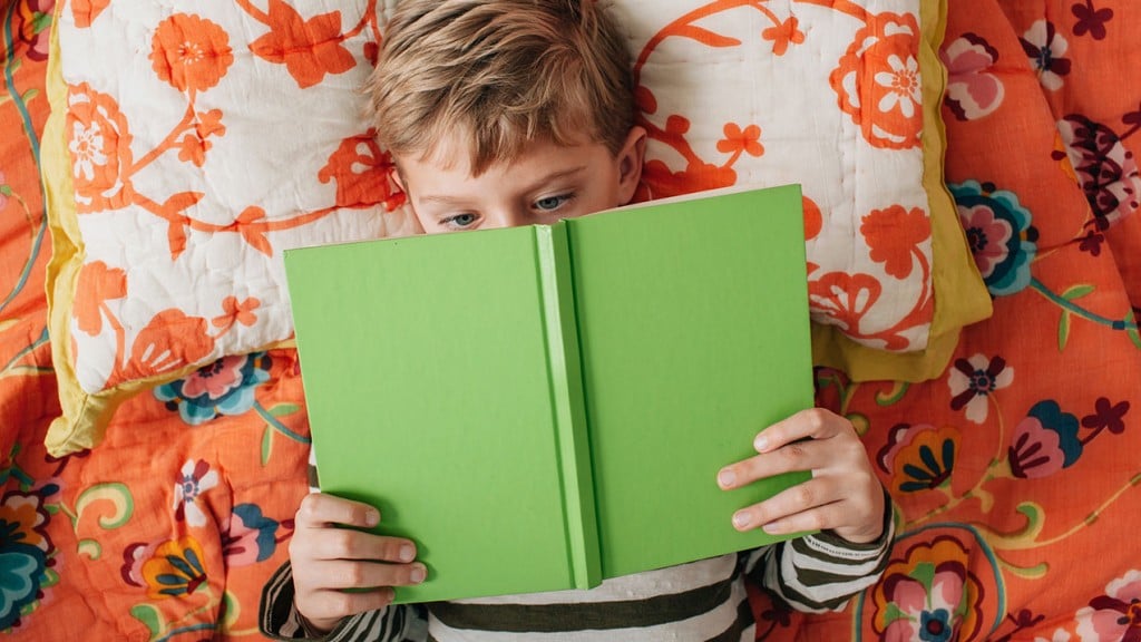 A child reads a green book