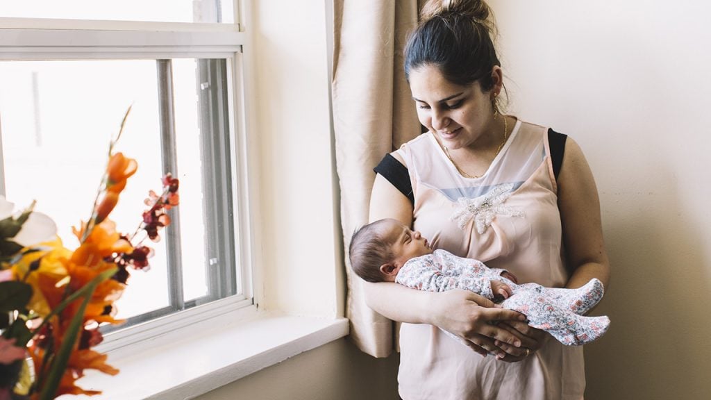 syrian mother holds her new baby born in canada