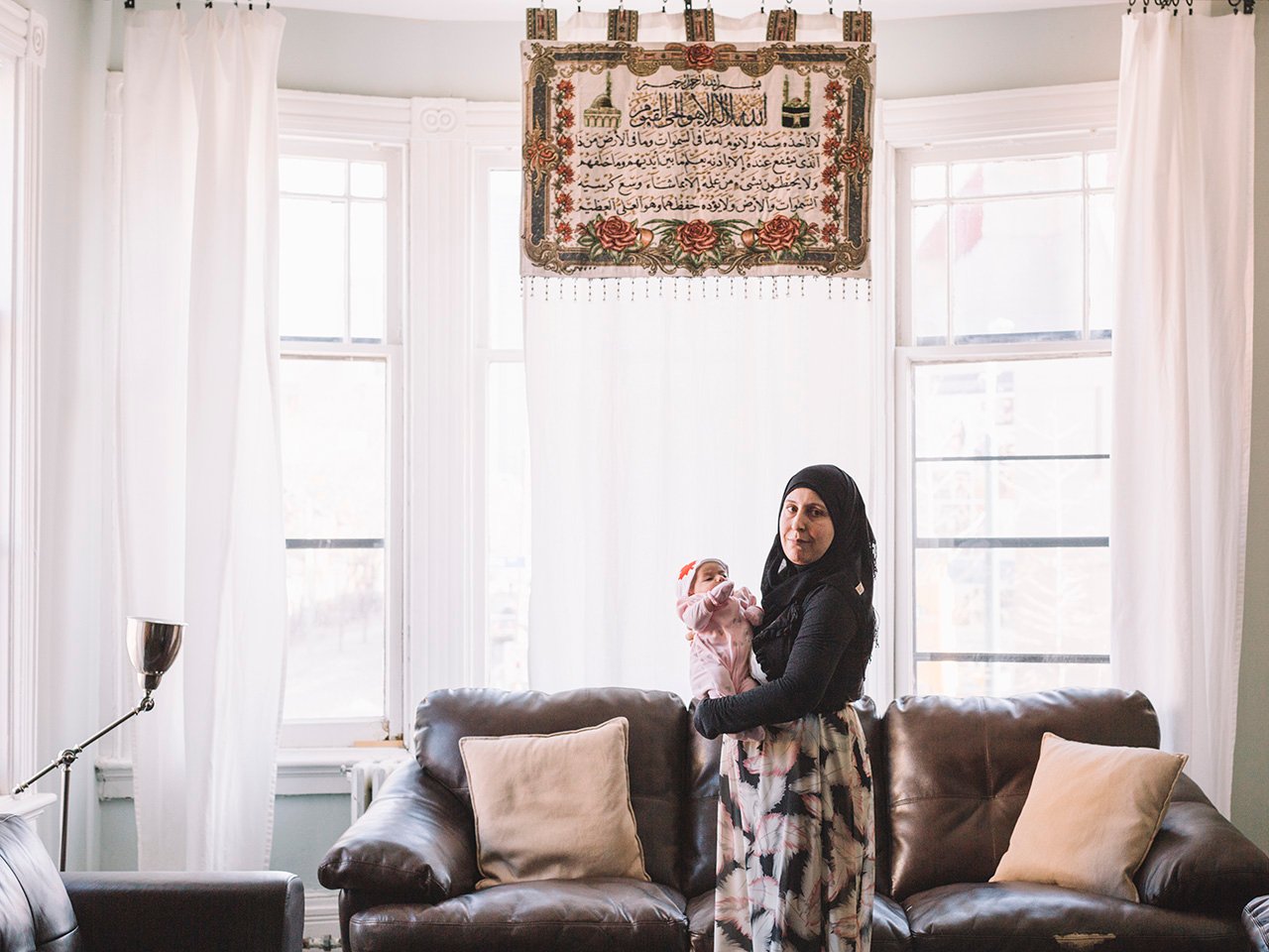 Zaka holds her new daughter in their apartment in Toronto