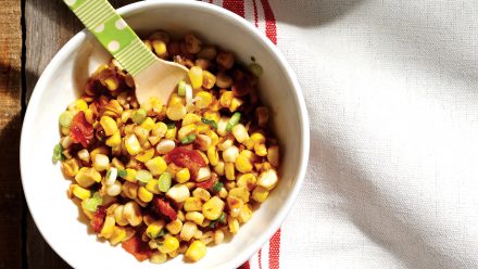 bowl of bacon and corn hash with wooden spoon
