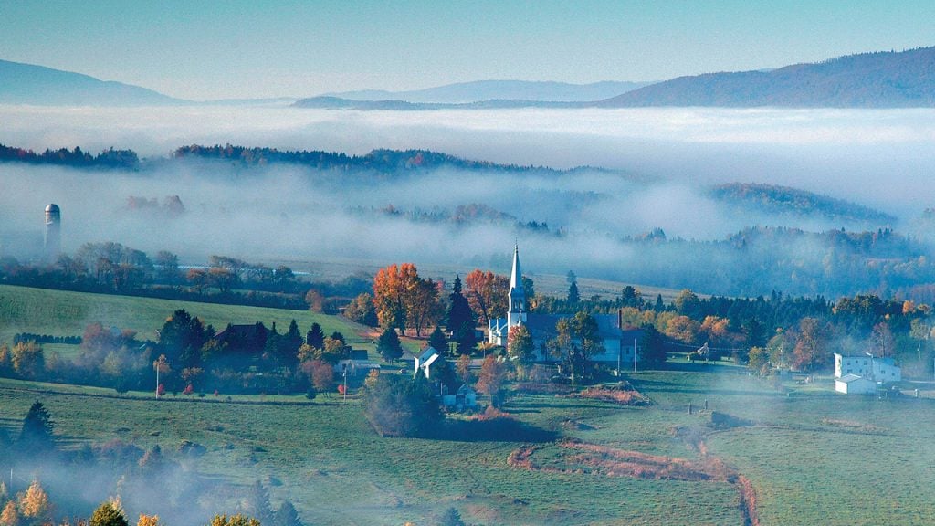 Fog settling over a small town in the foothills of the mountains in fall