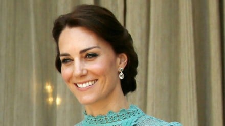 Kate Middleton smiling in a lace mint green dress
