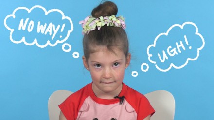 A little girl looking displeased with thought bubbles coming out of her head