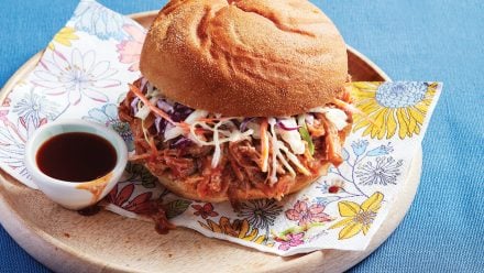 saucy pulled pork piled high on a bun with coleslaw