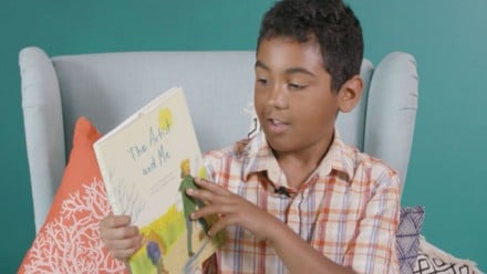 little boy sitting on couch and holding his favourite book