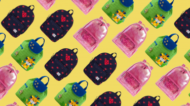Green, pink and black backpacks arranged on a yellow background