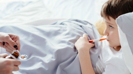 Child sick in bed getting medicine