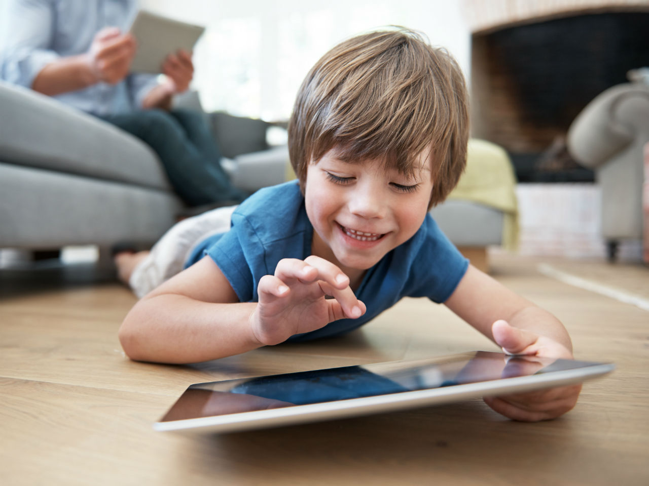 Little boy playing with tablet on floor
