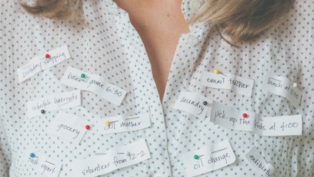 Woman with papers reading different activities pinned to her shirt