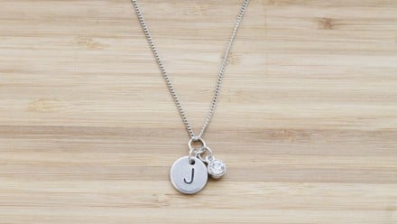 A necklace with the initial J and a small diamond