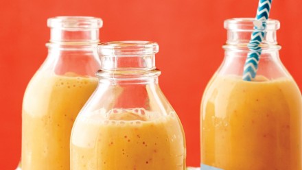 three bottles filled with creamy peach smoothie