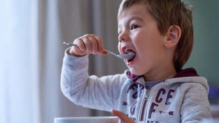Little boy eating a bowl of cereal following Canada's Food Guide