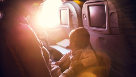 woman holding a baby in her lap on an airplane