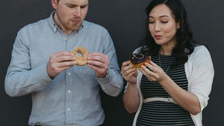 Man with pregnant woman eating doughnuts