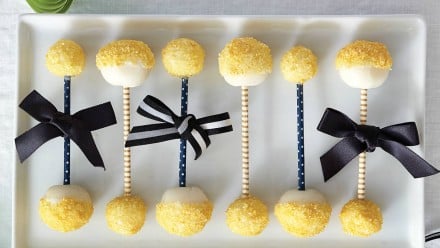 Edible rattles with yellow sprinkles and blue bows on them