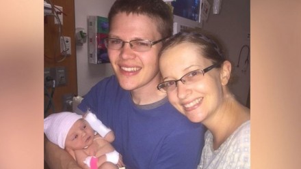 couple holds their newborn daughter in the hospital