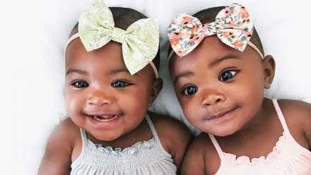 twin girls with headbands smiling at camera