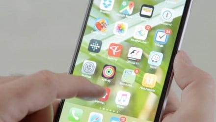 A hand clicking on an app in an iPhone