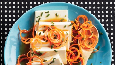 plate with sliced soft tofu drizzled with sauce and spiralled carrots