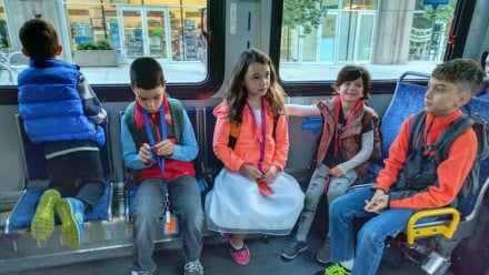 Four kids sitting on a city bus