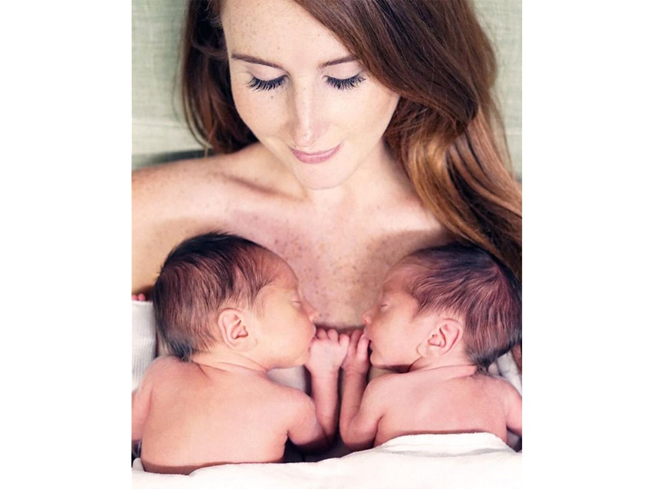 Jessi Cruickshank lying with her twins on her chest