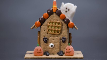 A house made of graham cracker with spooky candy on it
