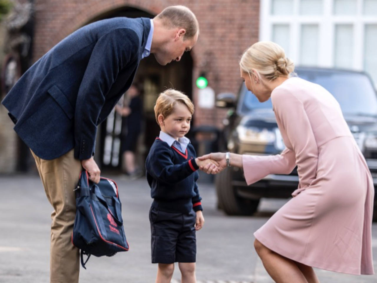 Prince George shaking new teacher's hand
