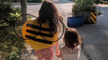 Two sisters taking a walk holding hands, one is wearing a bumblebee wings, stop teaching girls to be nice