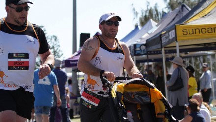 Dad pushes empty stroller while running a marathon alongside his friend