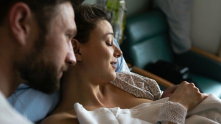 New parents holding their newborn baby in the hospital