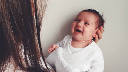 A baby smiling at a woman