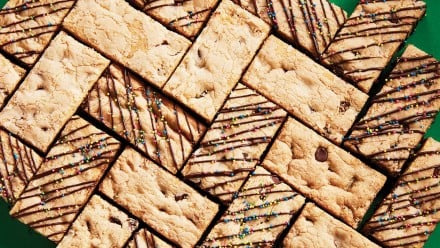 Chocolate chip cookie bars arranged on a green background