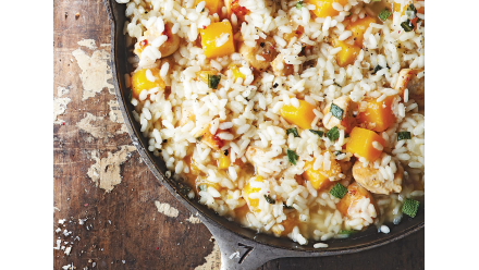 cast iron skillet of risotto with chunks of pumpkin and chicken