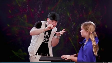 A magician doing a magic trick with a paper clip for a kid