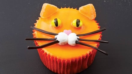 A cupcake decorated to be an orange cat