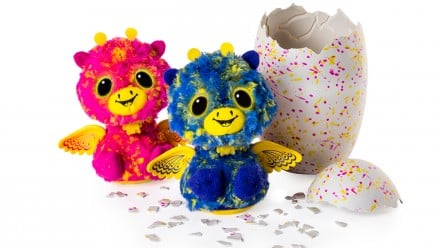 Pair of Giraven twins from the new Hatchimals Surprise egg. The creatures looks like multicoloured giraffes with wings. The twins are fraternal as one is pink and the other is blue. They sit next to a broken Hatchimals eggs