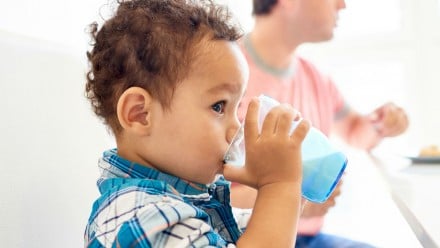 Toddler boy drinking a glass of milk