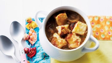 bowl of French onion soup with croutons on a colourful placemat